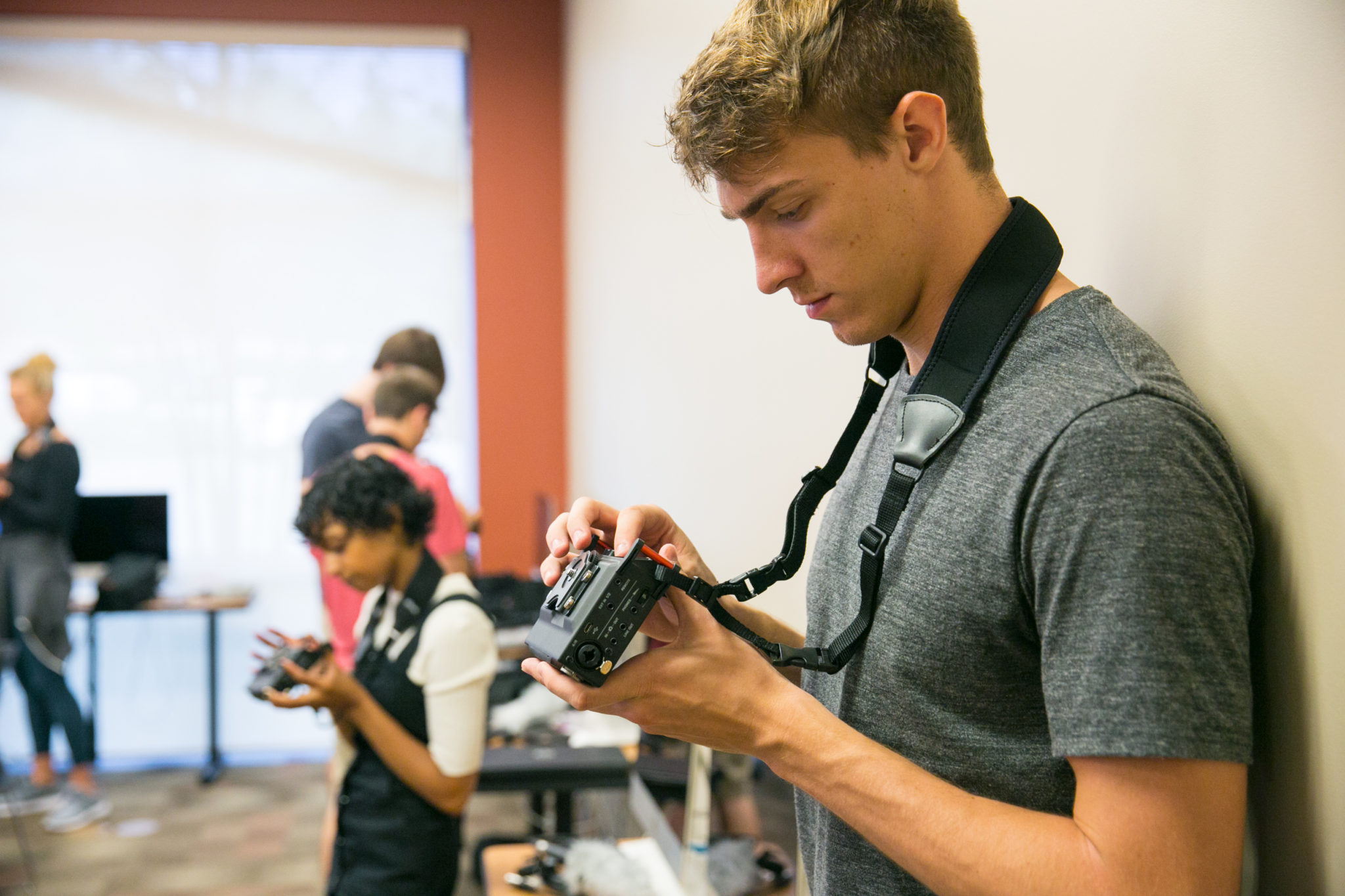 Student looks at back of digital camera.